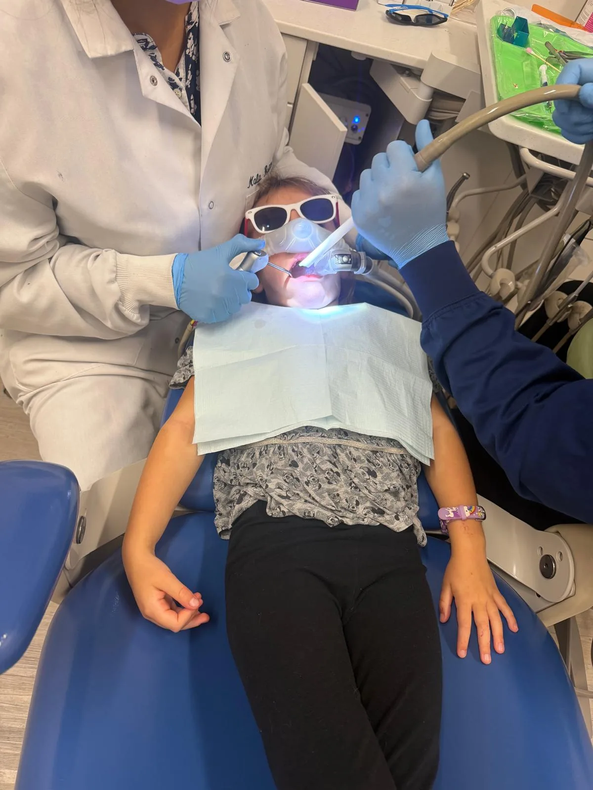 Child wearing protective glasses while a filling is cured with a dental curing light