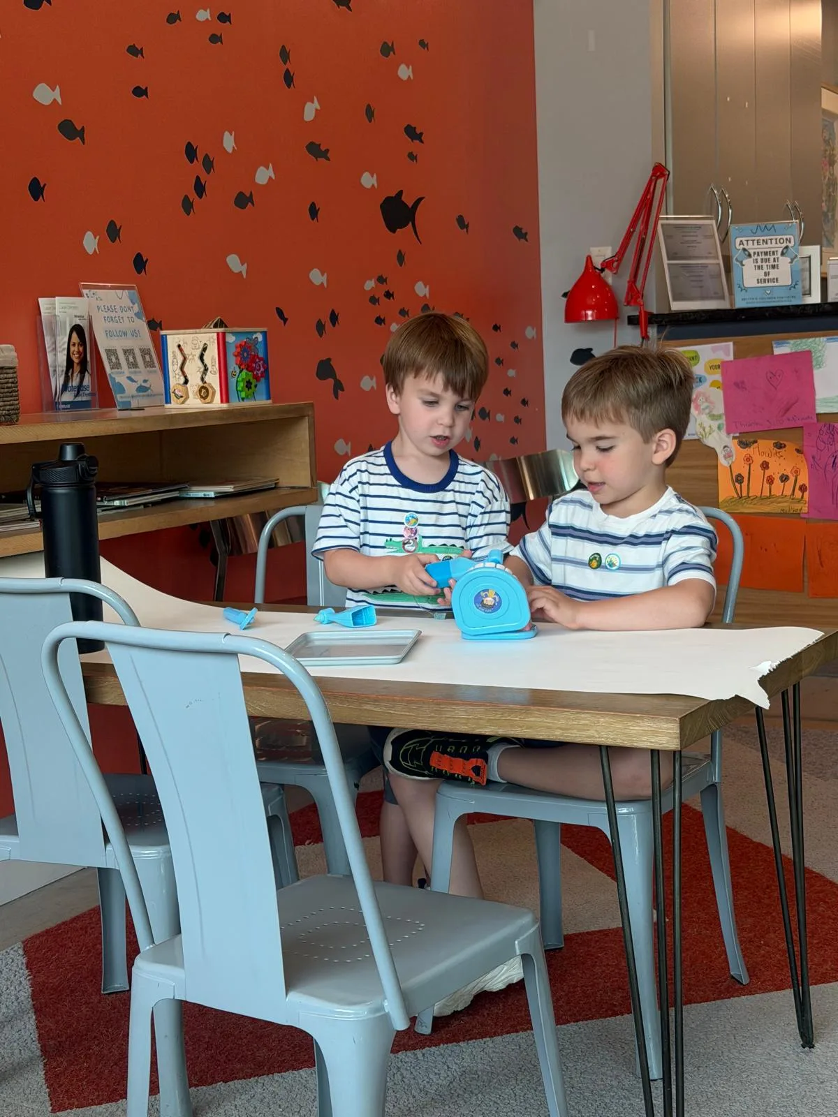 Children playing at the activity table in the Britto Children Dentistry waiting area